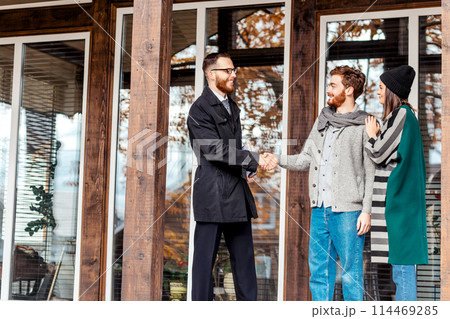 Young couple with real estate agent near house 114469285