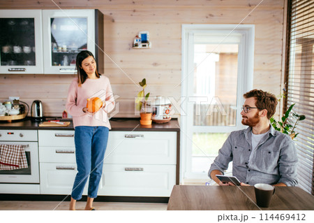 Young couple spending morning in new home, discussing their plans for future. Young couple spending morning in new home, discussing their plans for future. 114469412