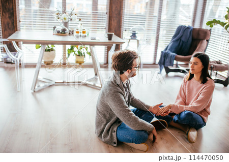 Couple in kitchen spending time together with cup of coffee and smartphone 114470050