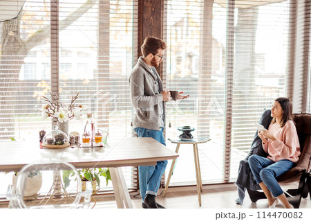 Young couple spending morning in new home, discussing their plans for future 114470082