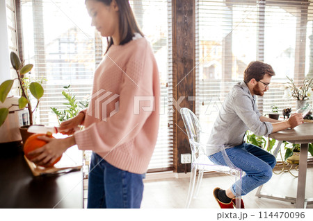 Young couple spending morning in new home, discussing their plans for future. Young couple spending morning in new home, discussing their plans for future. 114470096