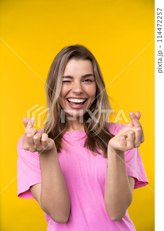 Happy emotions concept. Positive and beautiful young woman laughs poisitively looks aside with carefree face expression wears casual orange sweater isolated over yellow studio background. 114472257