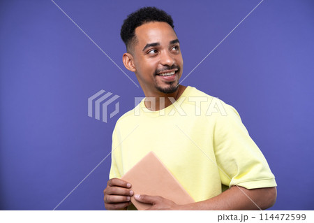 Emotional young black guy in casual raising fists up studio background, celebrating success, happy handsome african american millennial man sharing good emotions, copy space 114472599