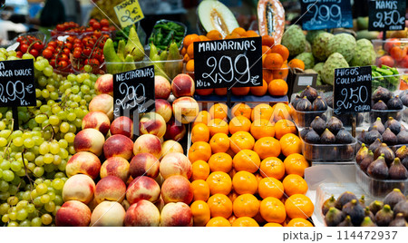 Green grape, mandarins, nectarines, figs for sale. Fresh and organic vegetables and fruits at farmers market. Bunch of bio vegetables sold on market stall. Agriculture and harvesting, food concept 114472937