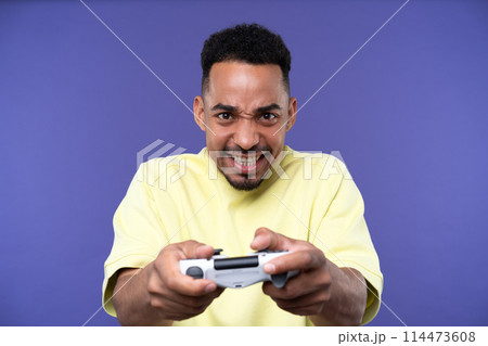 Emotional young black guy in casual raising fists up studio background, celebrating success, happy handsome african american millennial man sharing good emotions, copy space 114473608