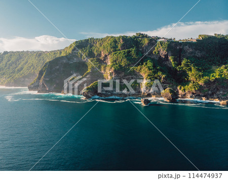 Panoramic landscape with rocky coastline and ocean with sunshine in Indonesia. Aerial view. Panoramic landscape with rocky coastline and ocean with sunshine in Indonesia. Aerial view. 114474937