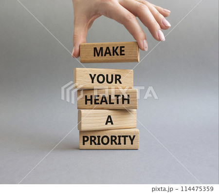 Health symbol. Wooden blocks with words Make your health a Priority. Doctor hand. Beautiful grey background. Health concept. Copy space. Health symbol. Wooden blocks with words Make your health a Priority. Doctor hand. Beautiful grey background. Health concept. Copy space. 114475359