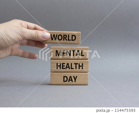 World Mental Health Day symbol. Wooden blocks with words World Mental Health Day. Businessman hand. Beautiful grey background. Health concept. Copy space. World Mental Health Day symbol. Wooden blocks with words World Mental Health Day. Businessman hand. Beautiful grey background. Health concept. Copy space. 114475393
