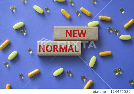 New normal symbol. Wooden blocks with words New normal. Beautiful purple background with pills. Medicine and New normal concept. Copy space. New normal symbol. Wooden blocks with words New normal. Beautiful purple background with pills. Medicine and New normal concept. Copy space. 114475526