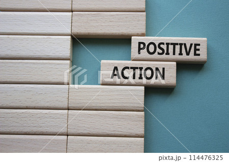 Positive action symbol. Concept words Positive action on wooden blocks. Beautiful grey green background. Business and Positive action concept. Copy space. 114476325