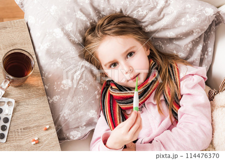 Little ill girl measuring temperature 114476370