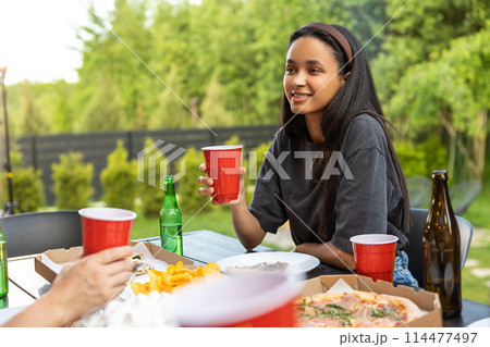 Smiling cheerful woman relaxing on picnic in open air Smiling cheerful woman relaxing on picnic in open air 114477497