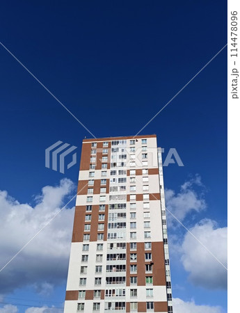 Modern apartment building on a background of blue sky with white clouds. Modern apartment building on a background of blue sky with white clouds. 114478096