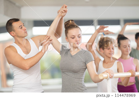 Ballet lesson for teenagers - choreographer teaches girls and boys ballet steps in studio Ballet lesson for teenagers - choreographer teaches girls and boys ballet steps in studio 114478969