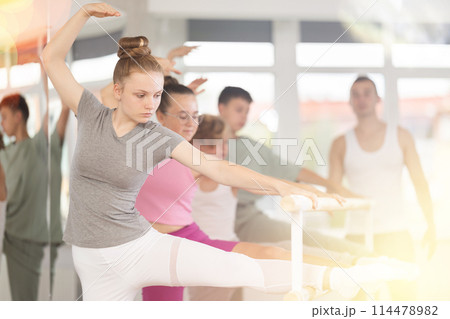 Ballet pose grand batman - girls and boys at a choreography lesson are learning ballet movements in studio 114478982