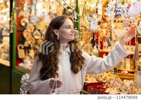 Woman choosing Christmas decorations Woman choosing Christmas decorations 114479008