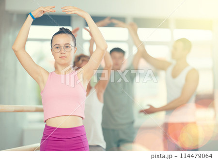 Teenage girl practicing ballet positions in dance studio Teenage girl practicing ballet positions in dance studio 114479064