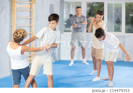 Teenagers sparring during group self-defense training with instructor 114479353