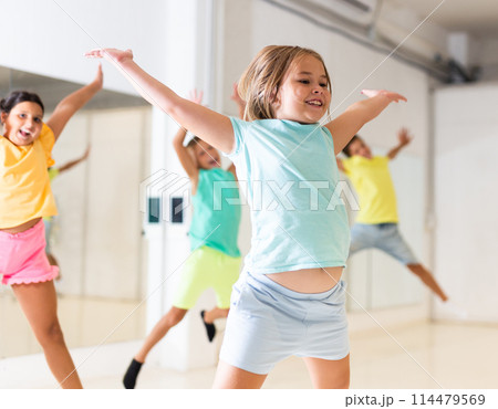Young girls and boys jumping together in dance room Young girls and boys jumping together in dance room 114479569
