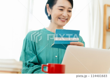預金通帳を確認するミドル女性 114481683