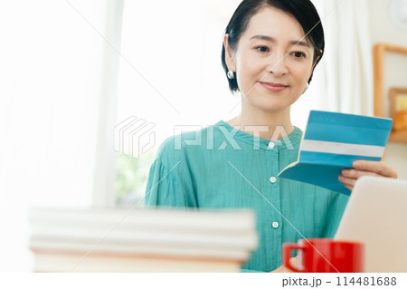 預金通帳を確認するミドル女性 114481688