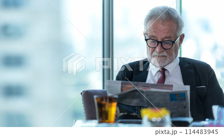 Business partner executive smart man sitting and reading newspaper in restaurant.  Business partner executive smart man sitting and reading newspaper in restaurant.  114483945
