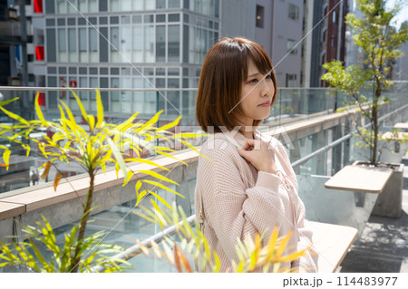 テラスでポーズをとる若く美しい女性 テラスでポーズをとる若く美しい女性 114483977