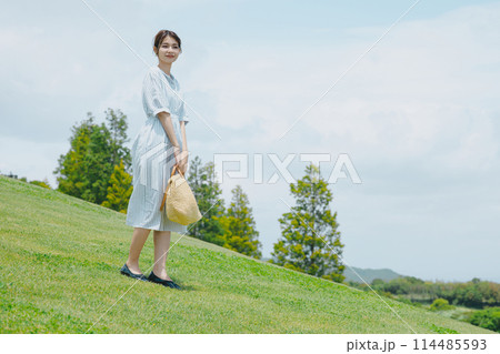 芝生の丘に立つかわいい女性 114485593