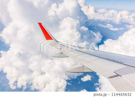 View from the airplane window at a beautiful cloudy sky and the airplane wing 114485632