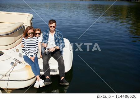 Family with daughter vacation together on sailboat in lake Family with daughter vacation together on sailboat in lake 114486626