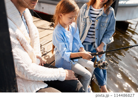 happy family with daughter fishing in pond in fall happy family with daughter fishing in pond in fall 114486827