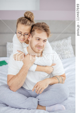 young awesome woman trying to make amends while hugging her boyfriend 114487649