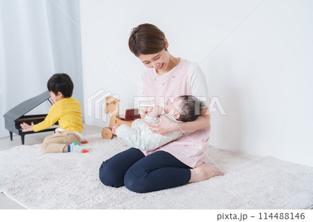 赤ちゃんにミルクをあげる保育士 114488146