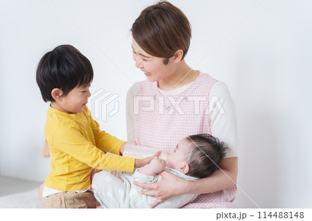 赤ちゃんにミルクをあげる保育士 114488148