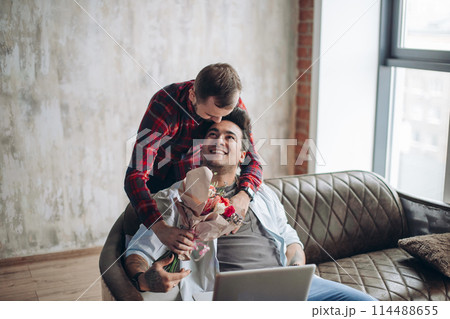 Romantic homo man presenting flowers to his beloved partner, Valentine's Day Romantic homo man presenting flowers to his beloved partner, Valentine's Day 114488655