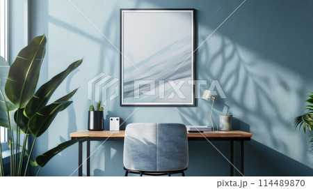 Empty picture frame mockup. A vertical wall art poster hanging on a wall above a desk. Empty picture frame mockup. A vertical wall art poster hanging on a wall above a desk. 114489870