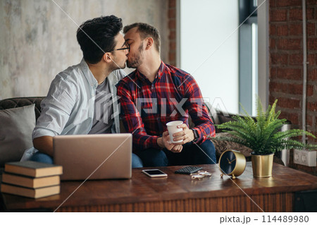 Man surprising his boyfriend with a present 114489980