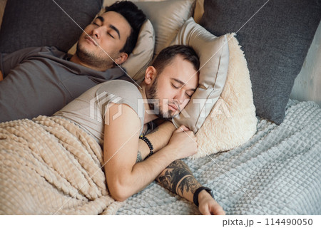 A homosexual couple on bed in studio with loft interior 114490050