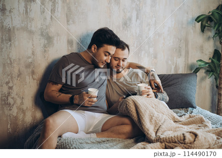 Perfect morning begins with lover and coffee in bed. Two guys resting in bed. 114490170