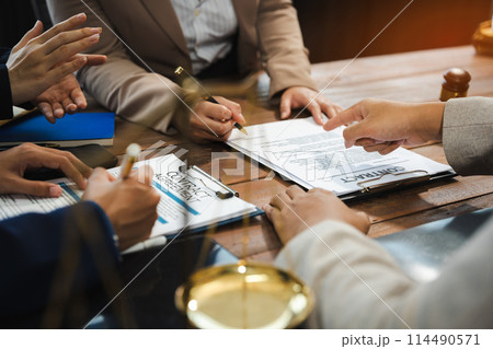 Teamwork of business lawyer meeting working hard about legal legislation in courtroom to help their customer.. Teamwork of business lawyer meeting working hard about legal legislation in courtroom to help their customer.. 114490571