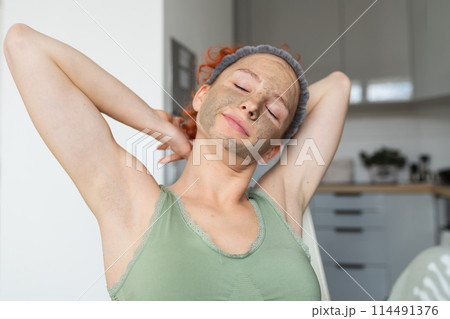 portrait young attractive positive woman in morning in cosmetic mask, in kitchen, having breakfast portrait young attractive positive woman in morning in cosmetic mask, in kitchen, having breakfast 114491376