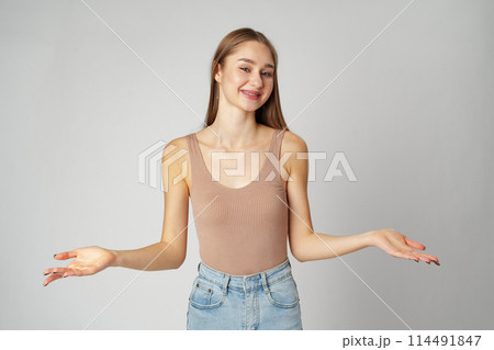 Clueless Young Woman Holding Out Her Hands Gesturing She Doesn't Know Clueless Young Woman Holding Out Her Hands Gesturing She Doesn't Know 114491847