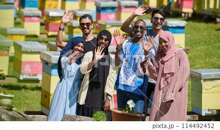 A diverse group of young friends and entrepreneurs explore small honey production businesses in the natural setting of the countryside. A diverse group of young friends and entrepreneurs explore small honey production businesses in the natural setting of the countryside. 114492452