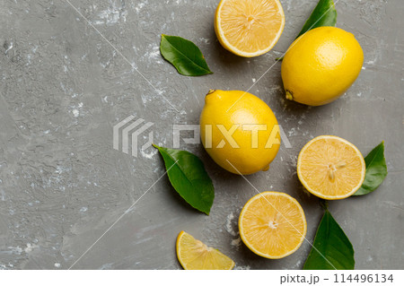 Many fresh ripe lemons with green leaves on colored background, top view, space for text Many fresh ripe lemons with green leaves on colored background, top view, space for text 114496134