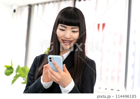 スマホを使う女性社員 114496185