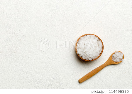 A wooden bowl of salt crystals on a wooden background. Salt in rustic bowls, top view with copy space 114496550
