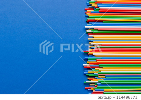 Heap of colorful plastic drinking straws on Colored background, flat lay. Copy Space for text 114496573