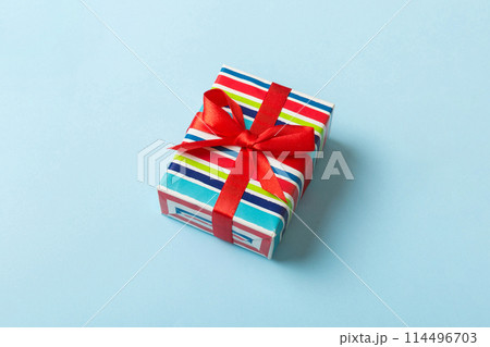 Wrapped christmas or other holiday handmade present in paper with colored ribbon. Present box, decoration of gift on table, top view with copy space Wrapped christmas or other holiday handmade present in paper with colored ribbon. Present box, decoration of gift on table, top view with copy space 114496703