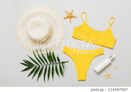 Woman swimwear and beach accessories flat lay top view. Top view with bikini outfit on color background. Vacation concept copy space 114497067