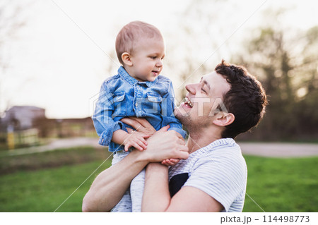 Father holding little toddler boy playing, having fun during warm spring day. Father's day concept. 114498773